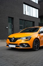 A modern orange and gray Remisse Atlántida car parked in front of the office on Hipólito Yrigoyen street.