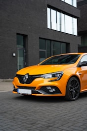 A vibrant car wrapped with a custom design parked in front of a modern office building.