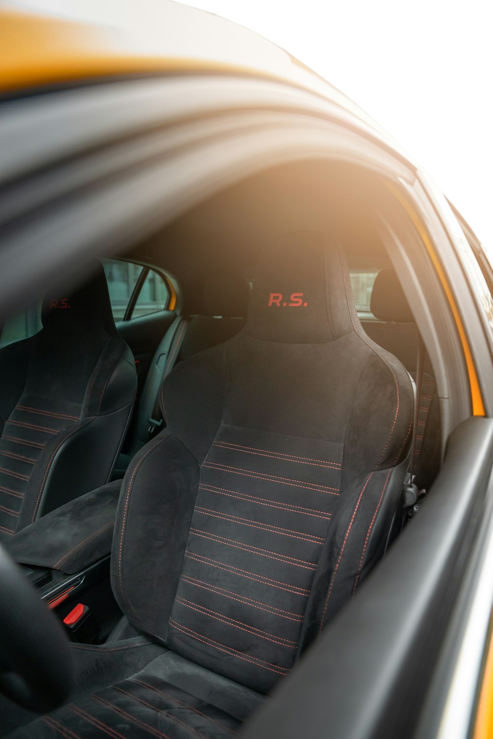 the interior of a car with black and red seats