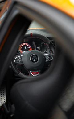 Close-up of a sleek steering wheel with mach1 logo, hinting at speed and precision.