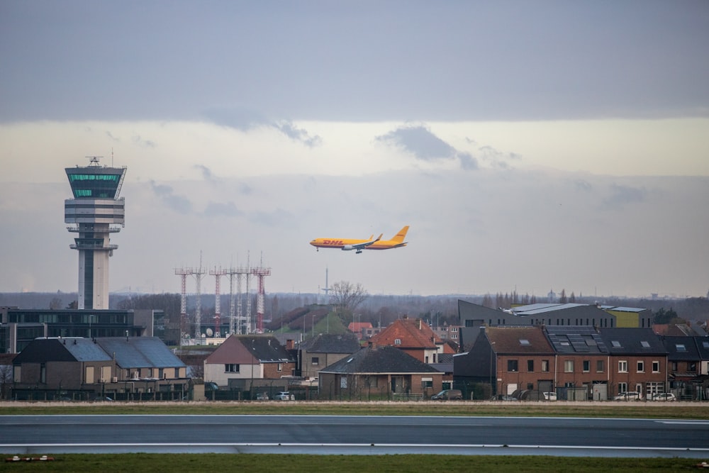 a large jetliner flying over a city under a cloudy sky