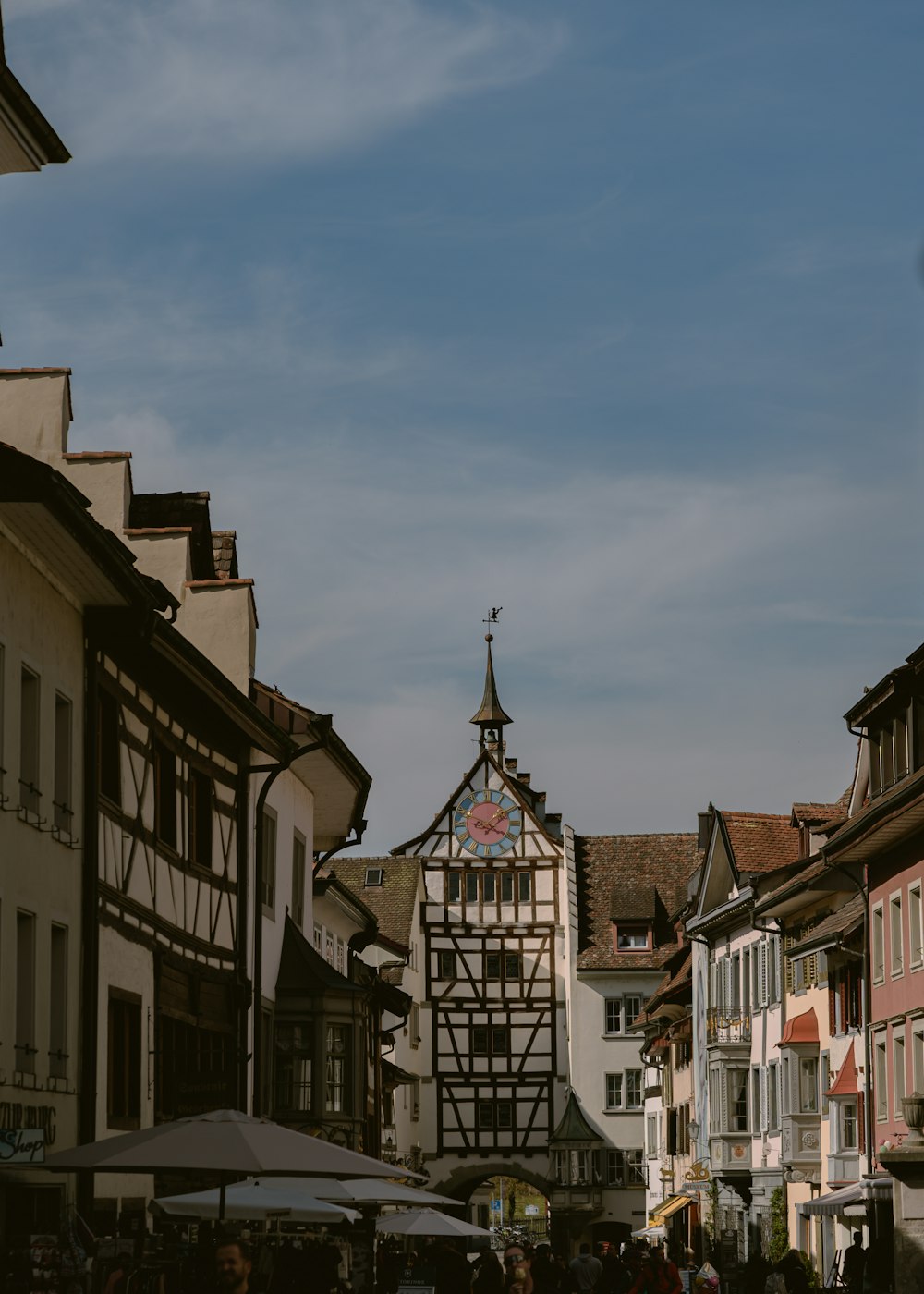 a group of people walking down a street next to tall buildings