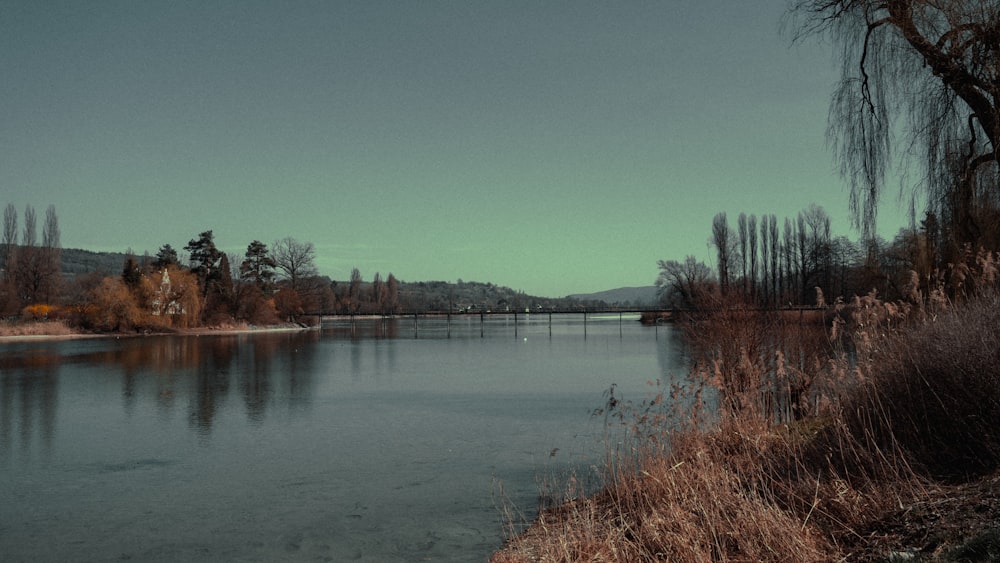 a body of water with a bridge in the background