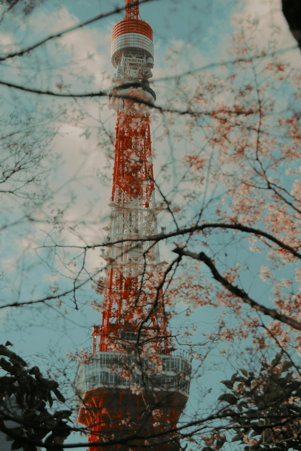 a red and white tower is seen through the trees