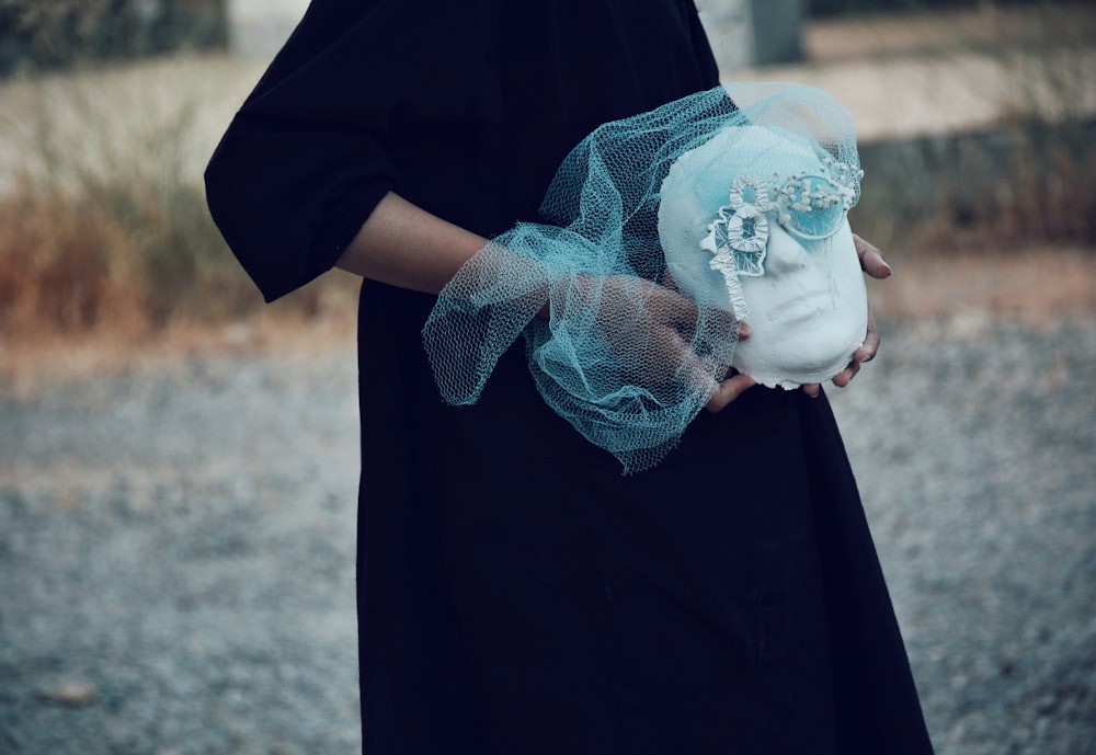 a woman in a black dress holding a white teddy bear