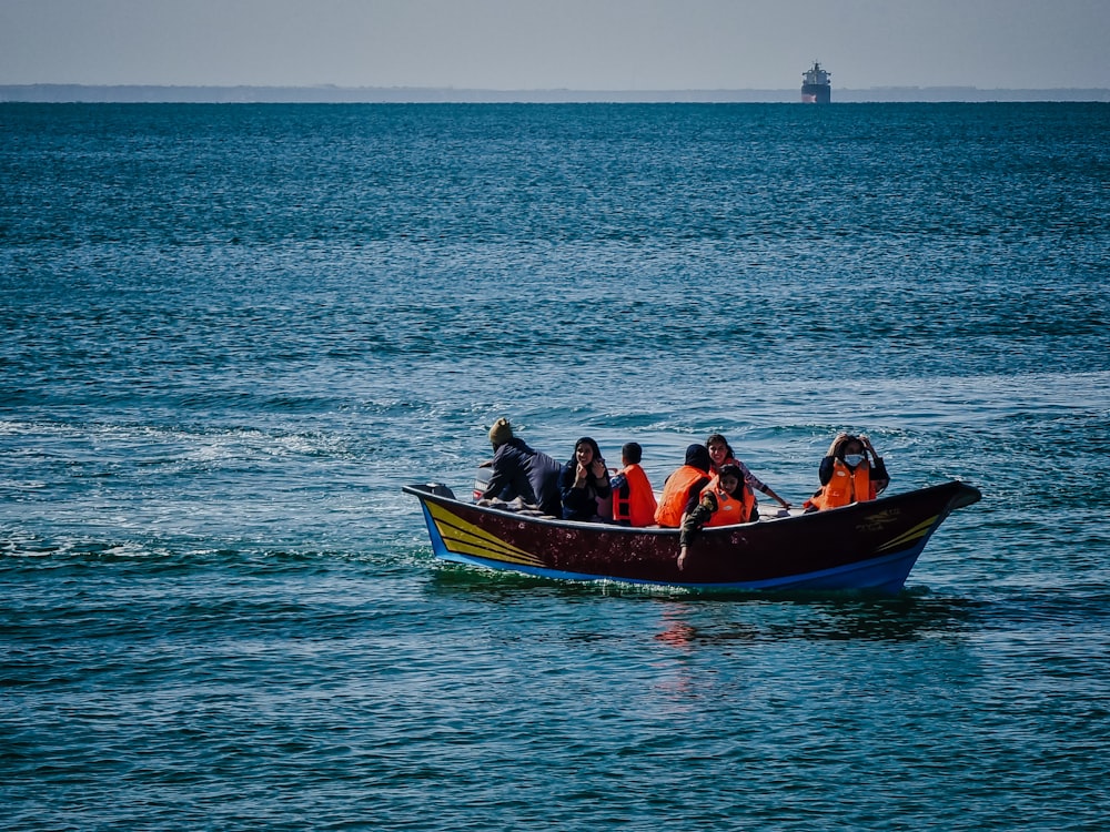 a group of people in a small boat in the ocean