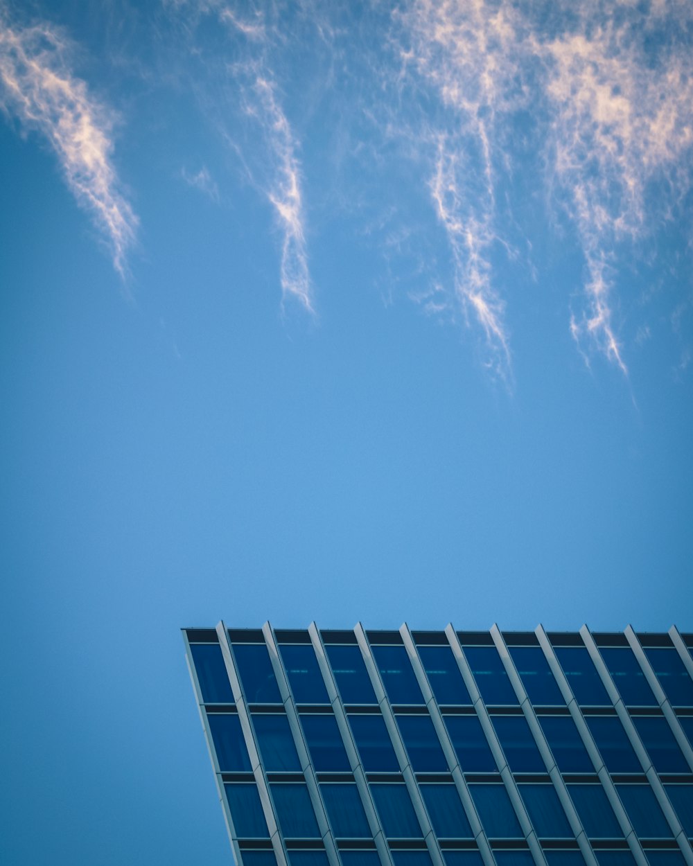 a plane flying in the sky over a building