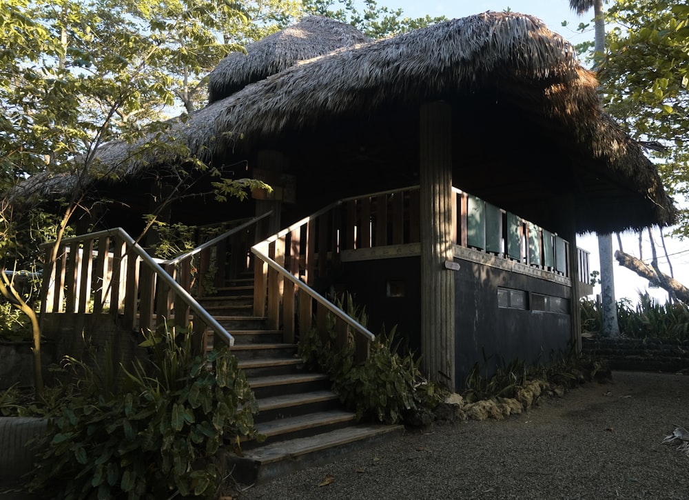 une maison avec un toit de chaume et des escaliers