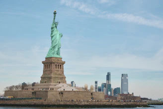 the statue of liberty stands in front of the city skyline