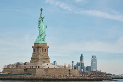 the statue of liberty stands in front of the city skyline