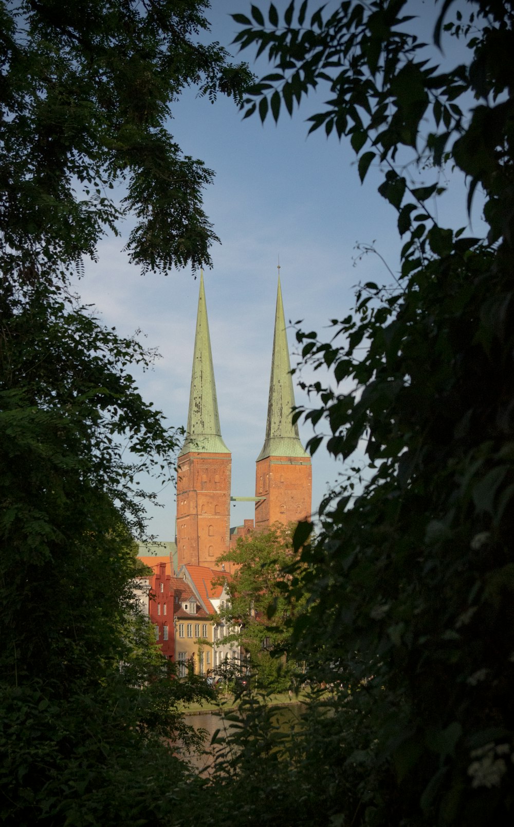 a tall building with two towers surrounded by trees