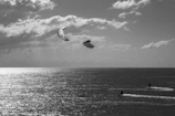 Kite-surfers catching the wind over the sparkling sea off the Sardinian coast during a breezy day.