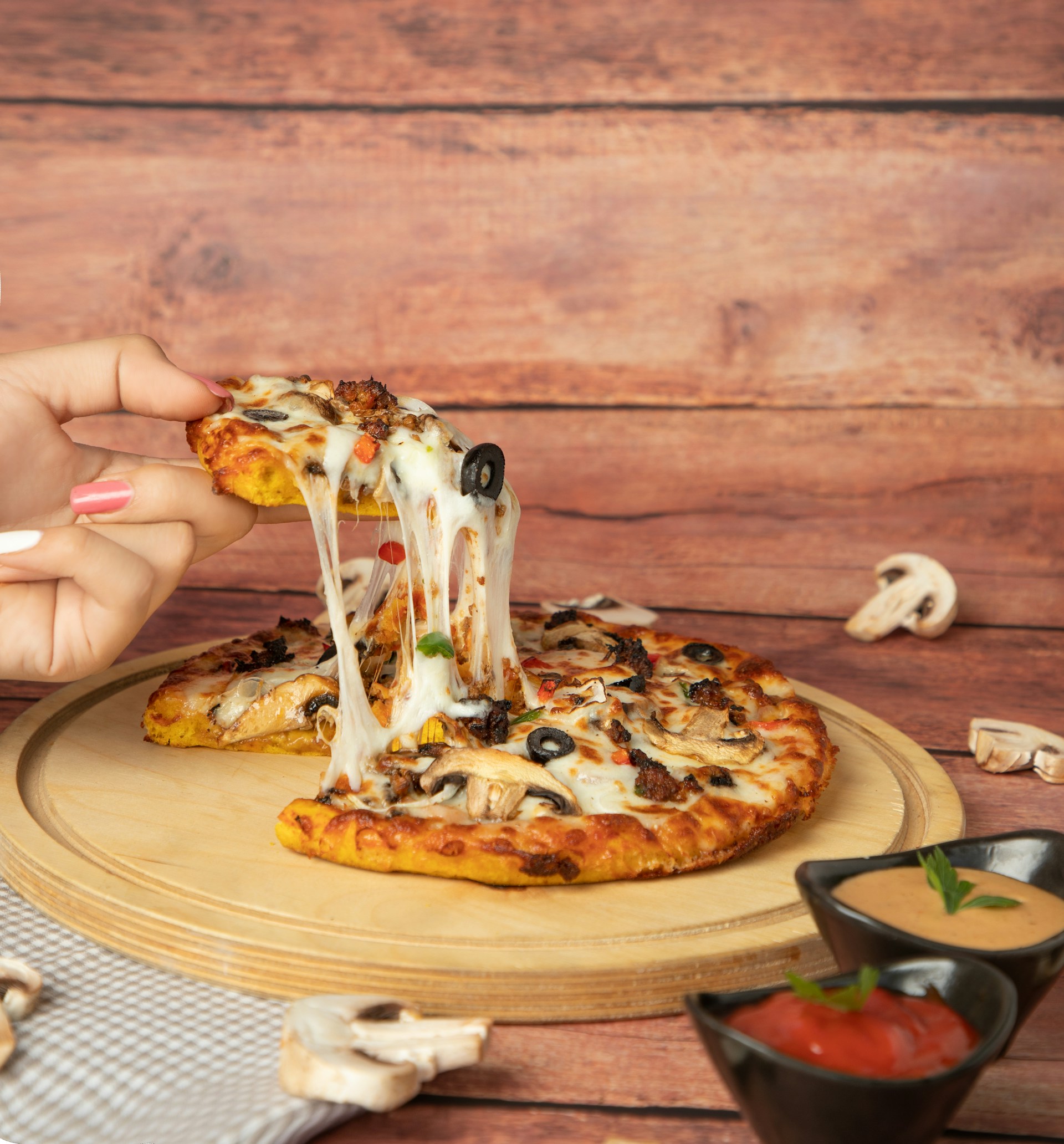 a person is taking a slice of pizza