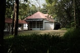 Wide shot of a house with a newly replaced red tile roof surrounded by greenery.