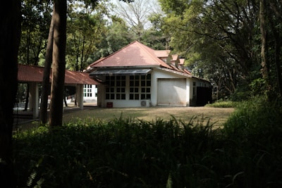 Wide shot of a house with a newly replaced red tile roof surrounded by greenery.