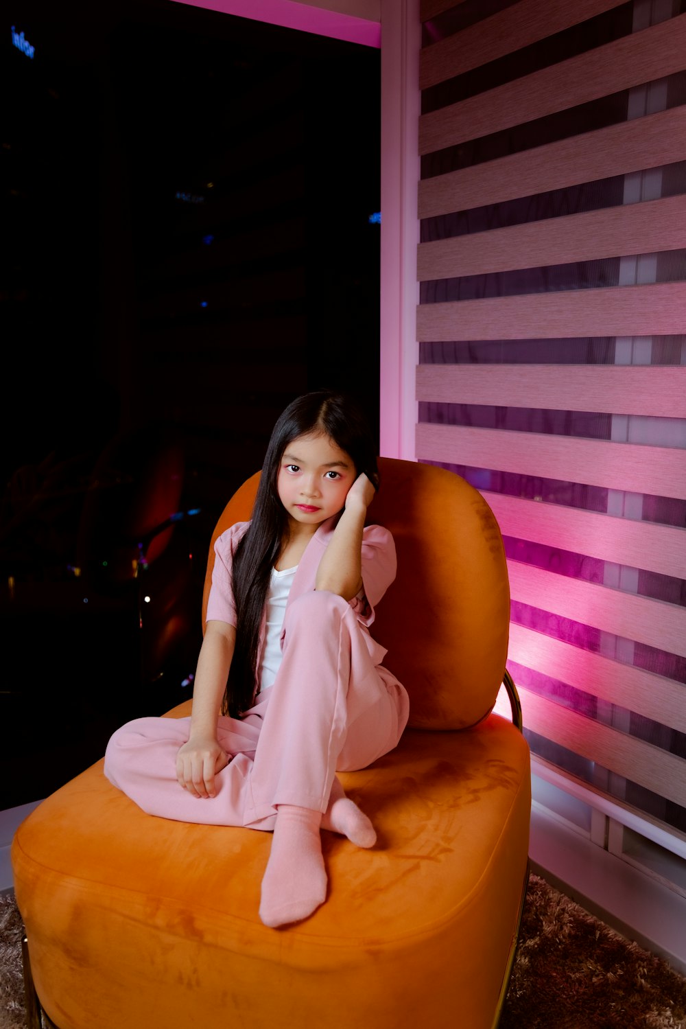 a little girl sitting on a chair in a room