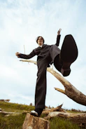 a man standing on top of a tree stump