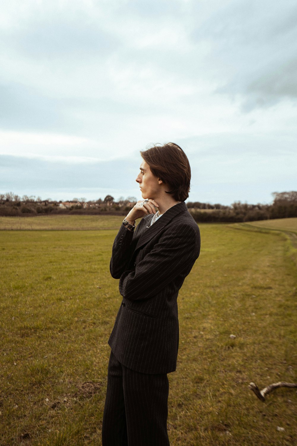 a woman in a suit standing in a field