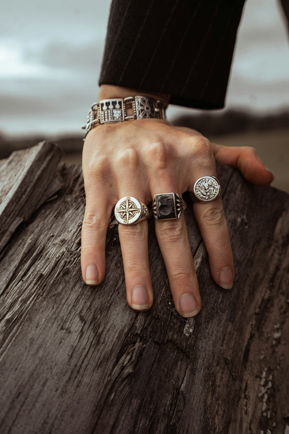 a person's hand with three rings on it