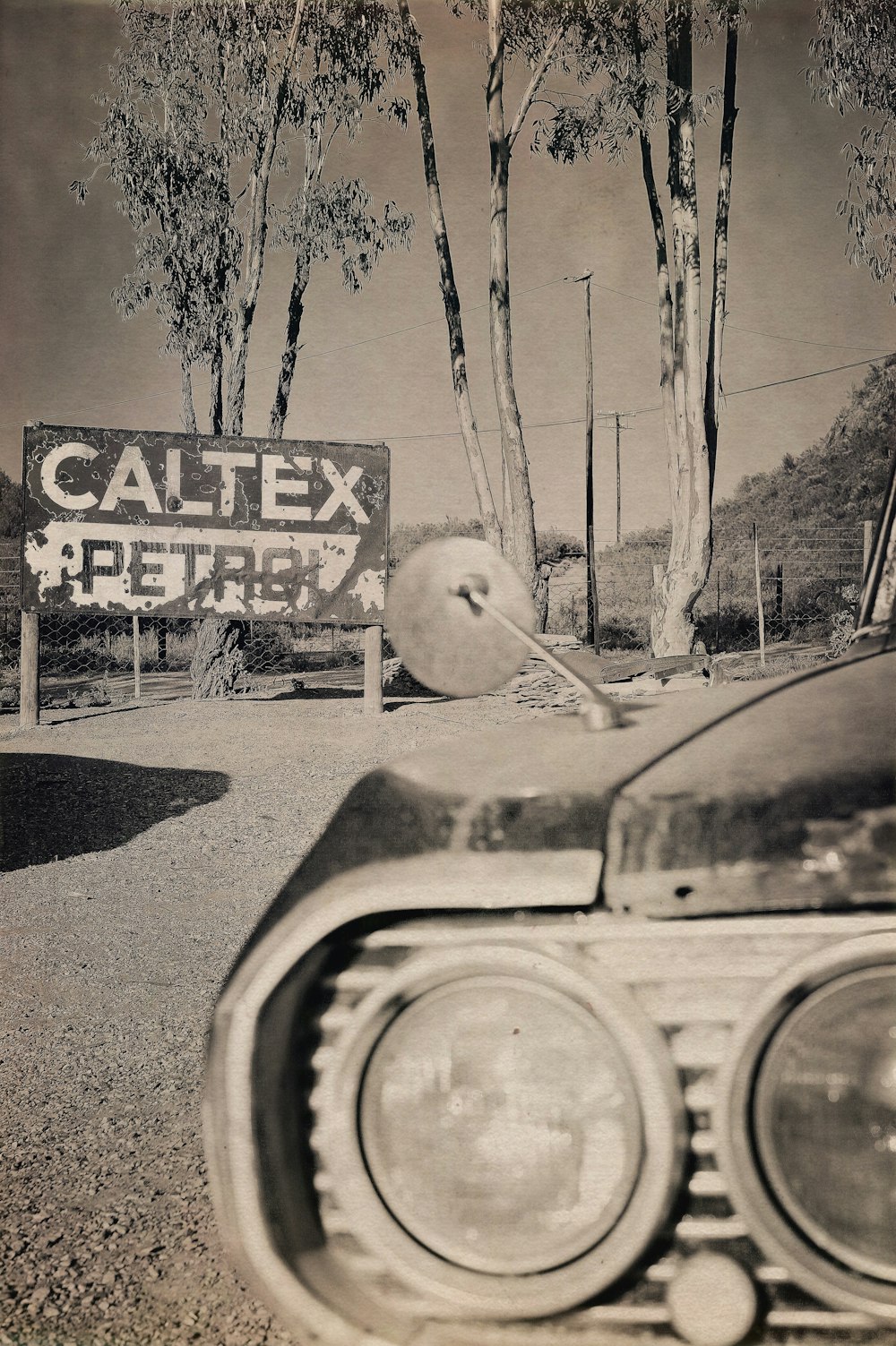 a black and white photo of a car parked in front of a sign