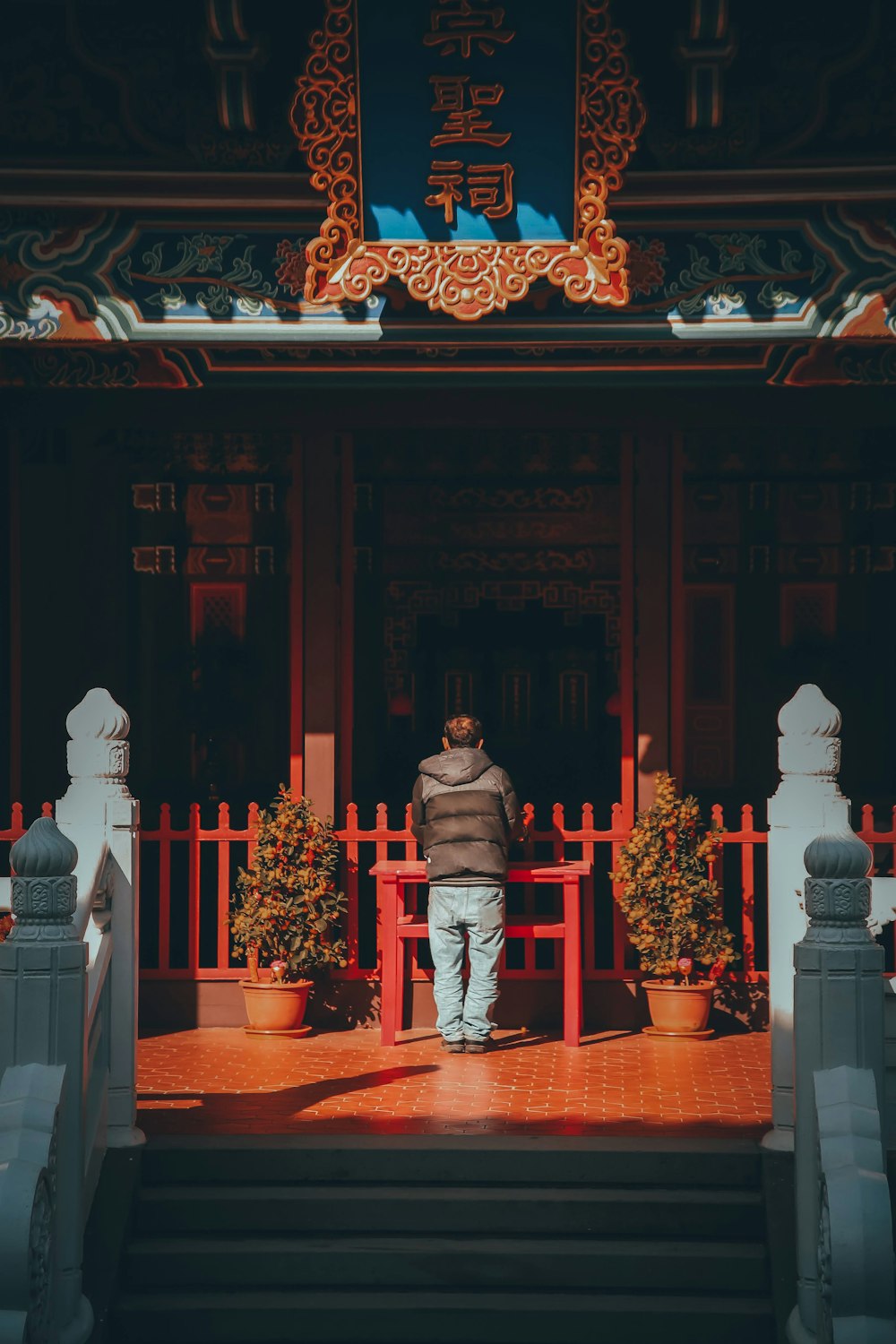 a man standing in front of a red building