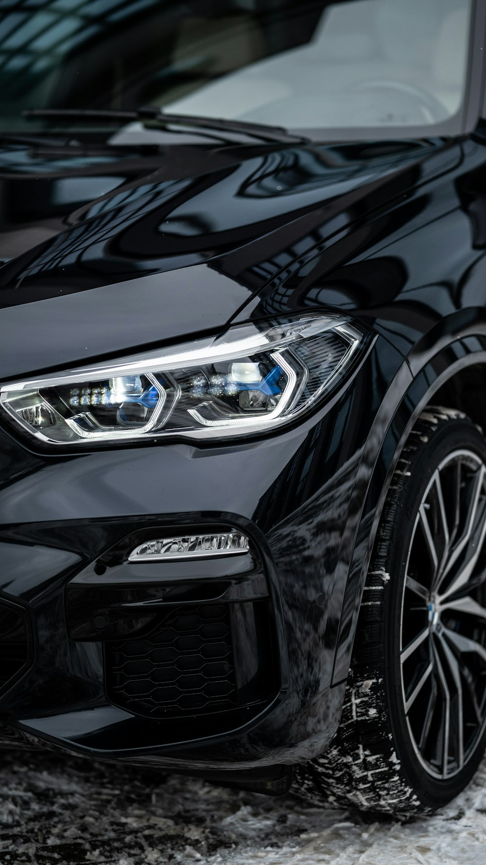 a black bmw car parked in a parking lot