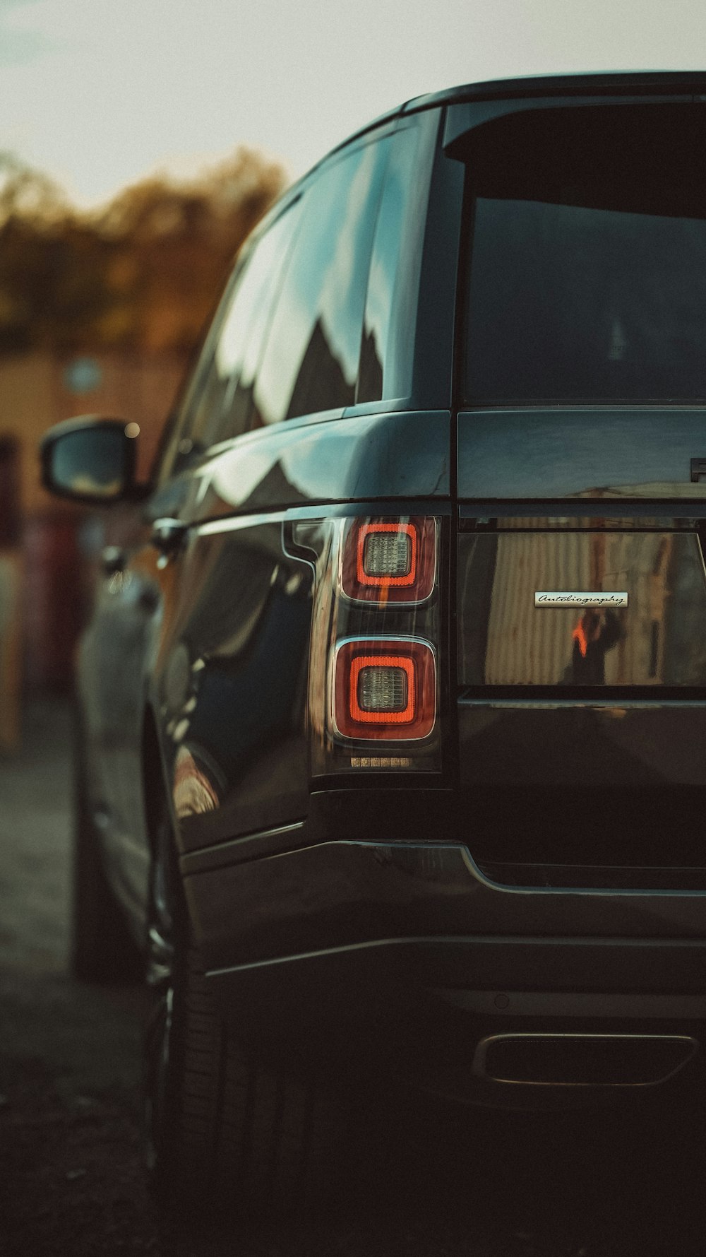 the back end of a black suv parked on a street