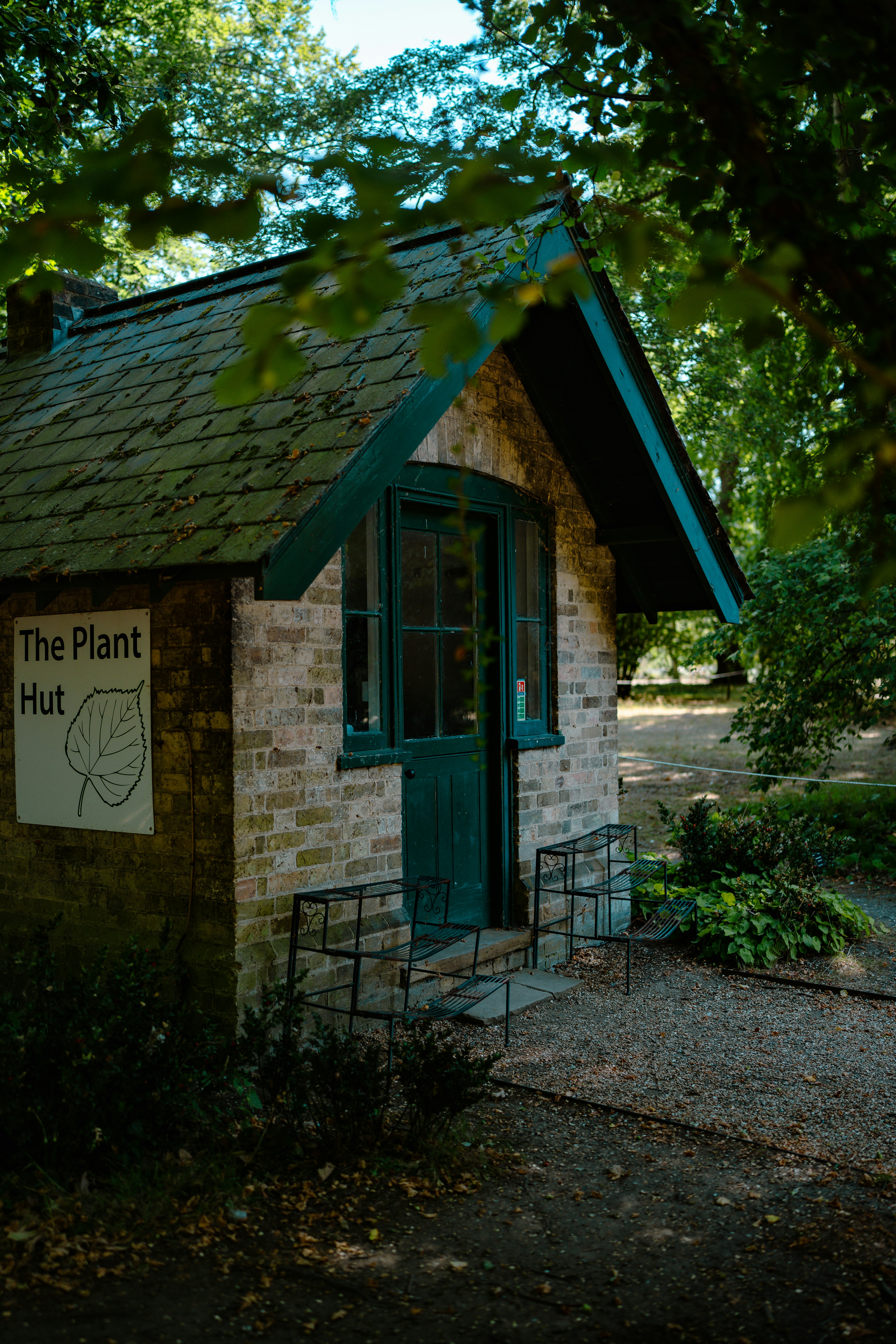 a small brick building with a green door