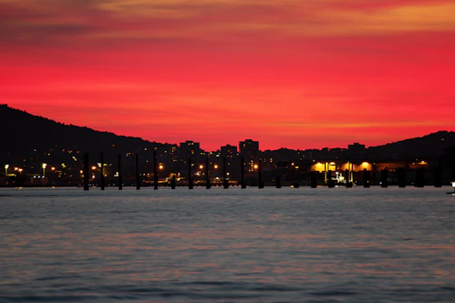 A sunset sky glowing in deep red hues over a city skyline.