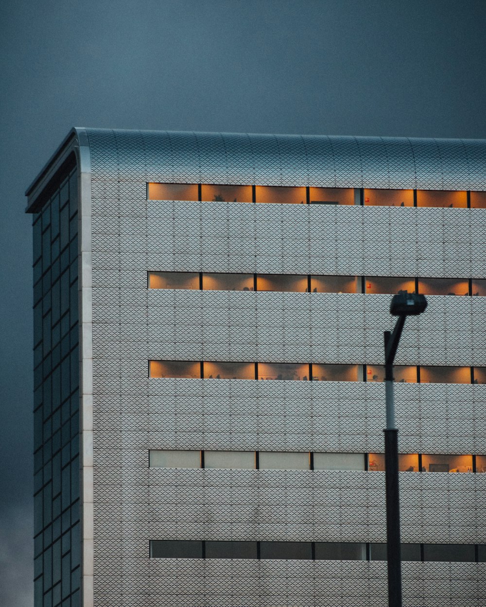 Un edificio alto con un lampione di fronte ad esso