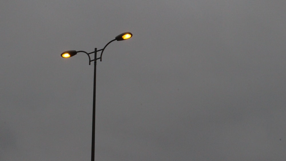 a street light with two yellow lights on top of it