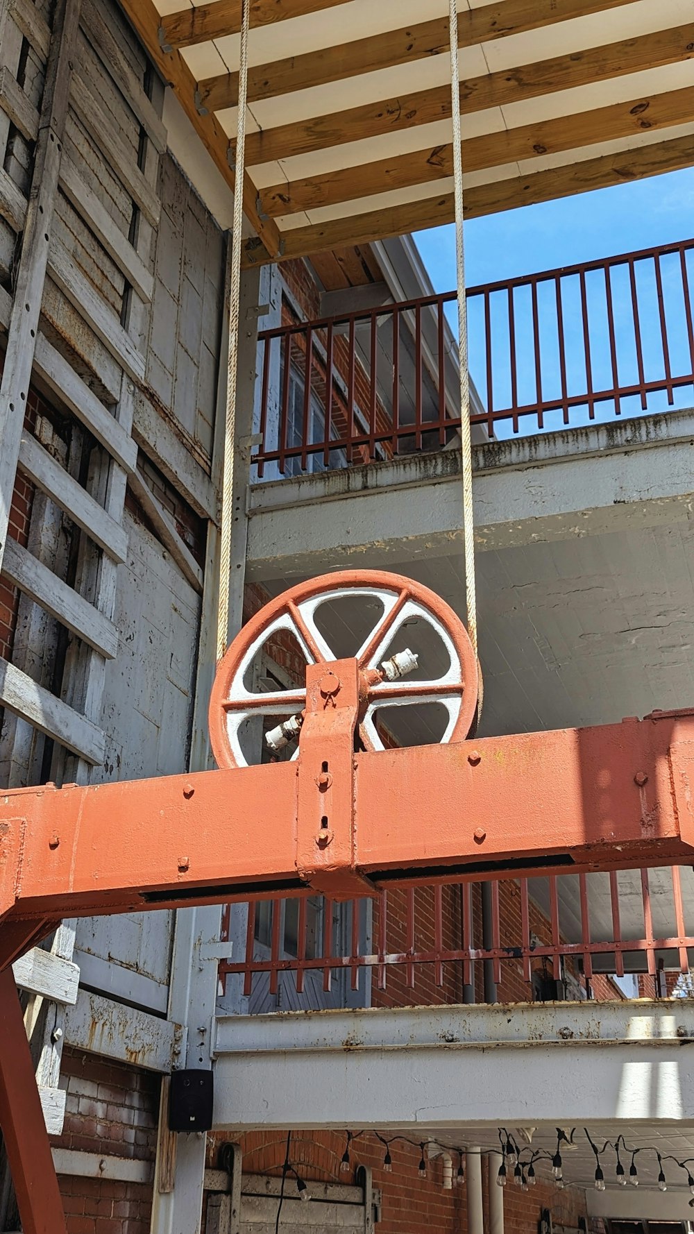 a large orange object hanging from a metal beam