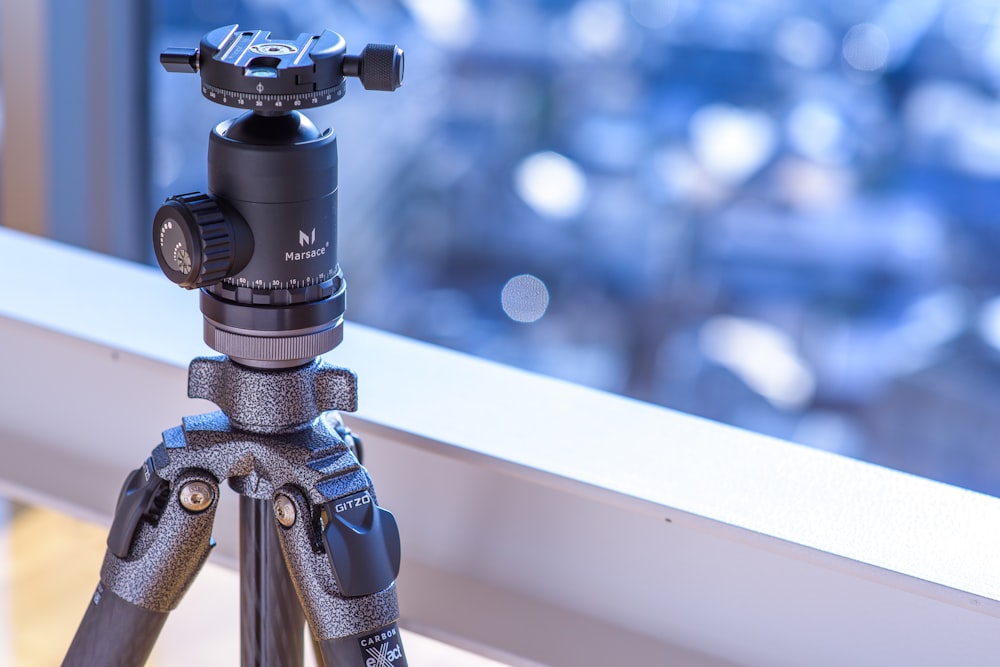 a tripod sitting on top of a window sill