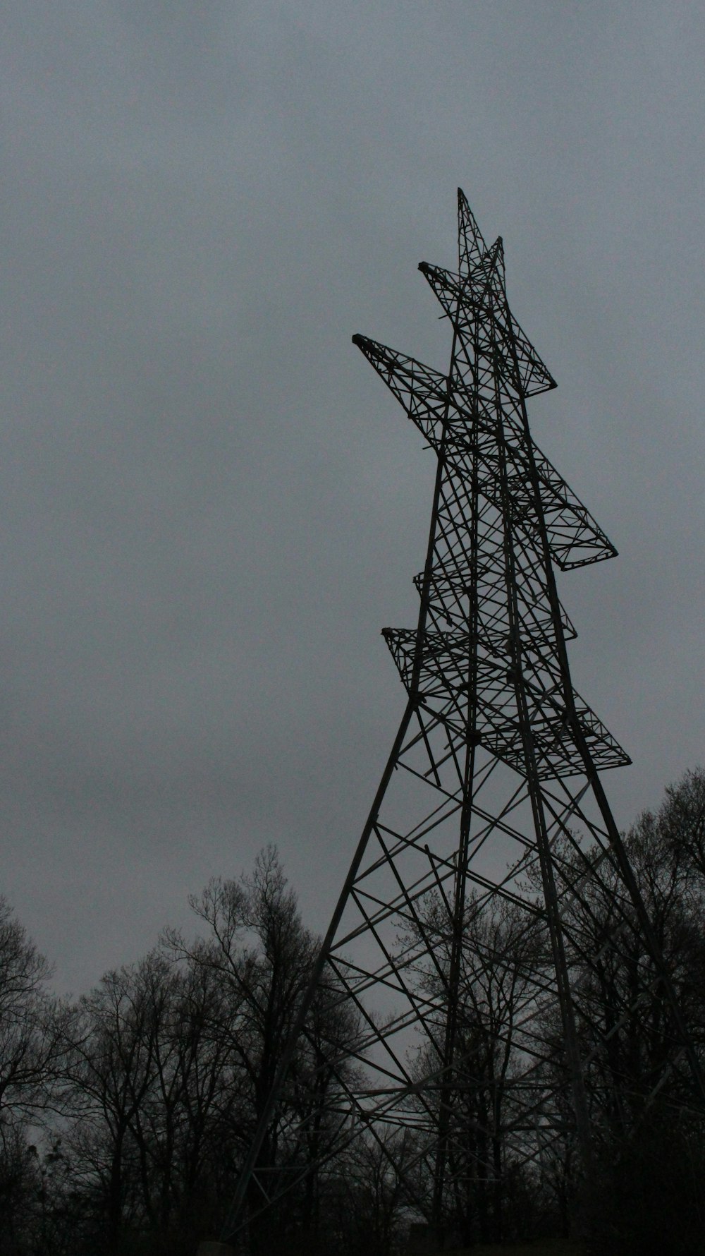 a tall metal tower sitting next to a forest