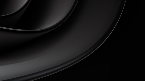 Curved, layered, glossy black surfaces create a sleek, abstract design with subtle reflections.