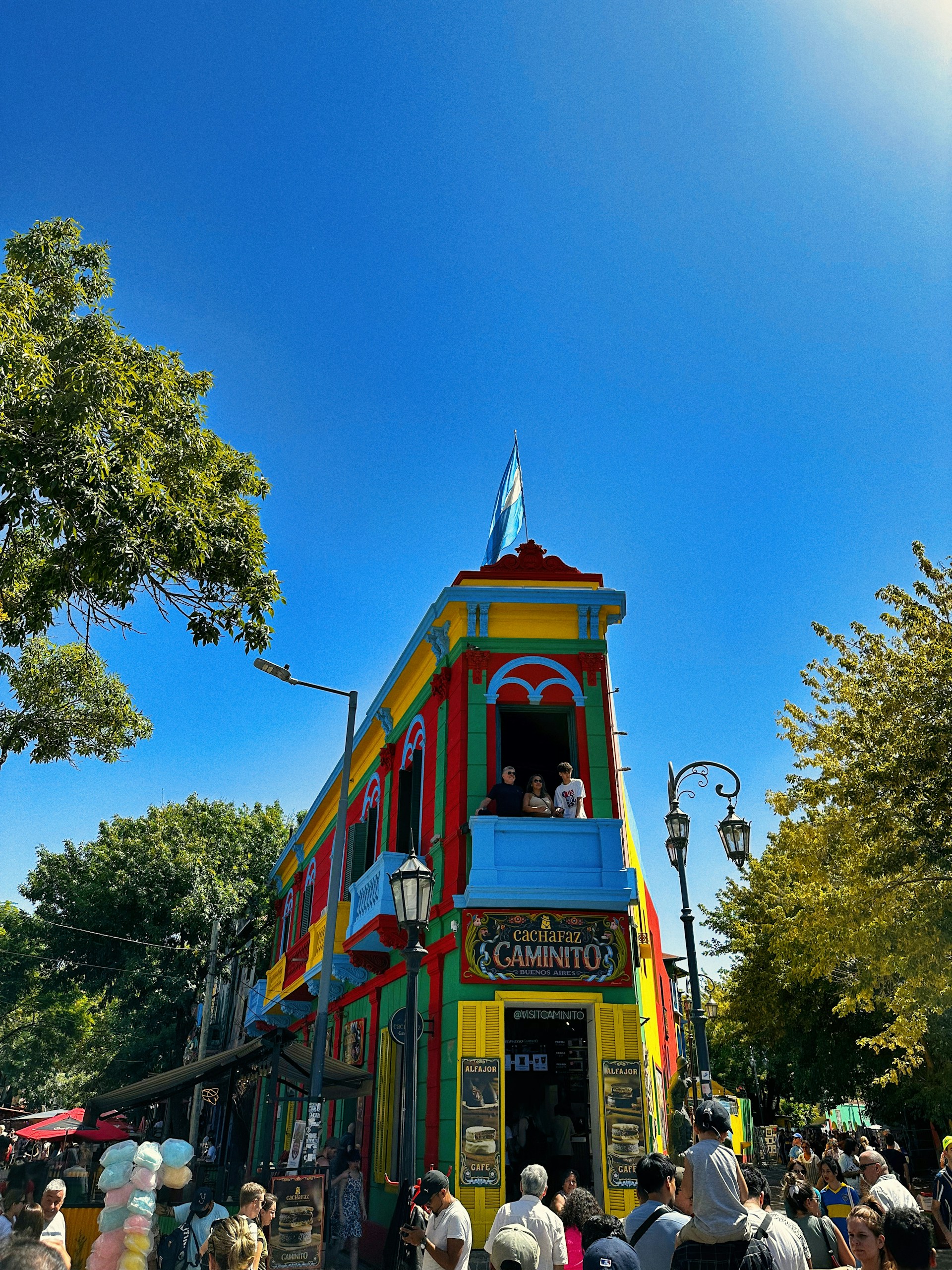 a colorful building with a crowd of people standing around it