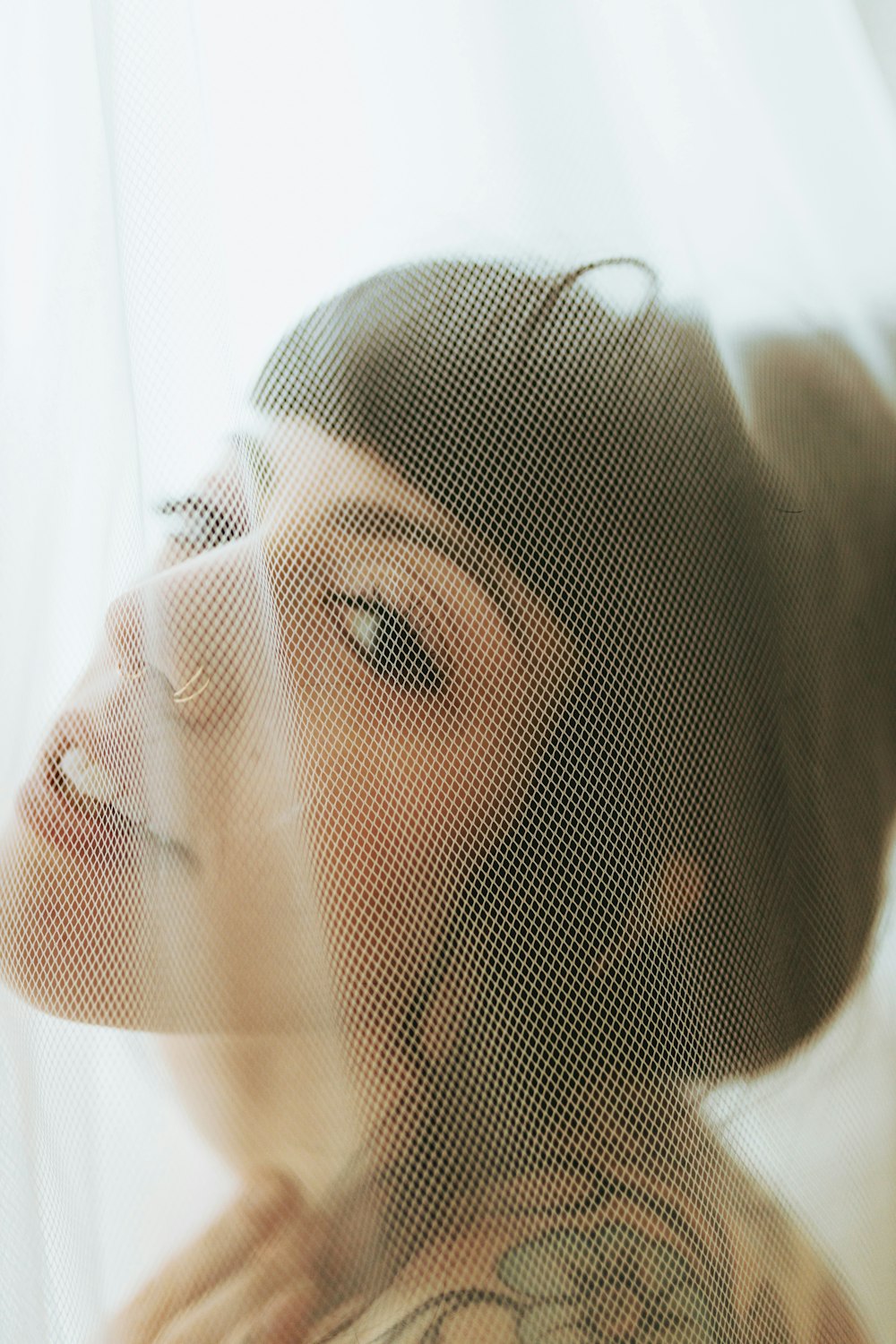 a woman looking out a window with a hat on