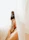 Close-up of a serene client admiring her healed areola restoration in a warm, inviting space.