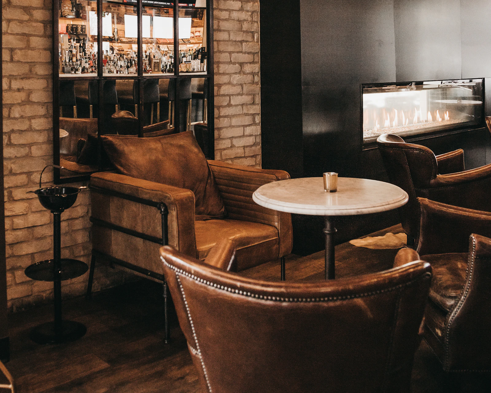 Dark lounge interior with leather furniture and a fireplace
