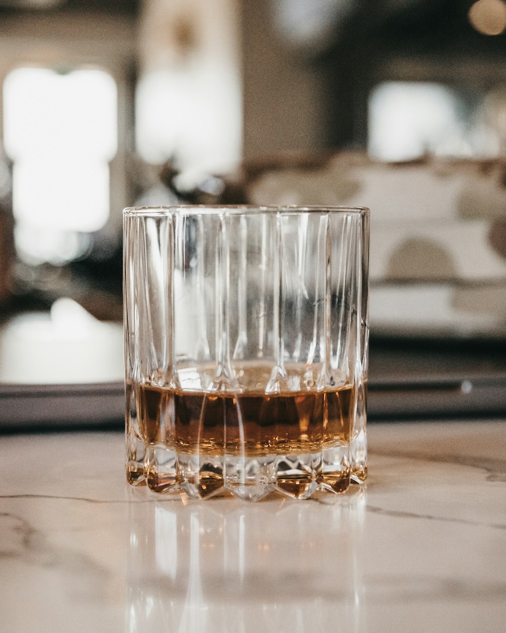 a glass of whiskey sitting on top of a table