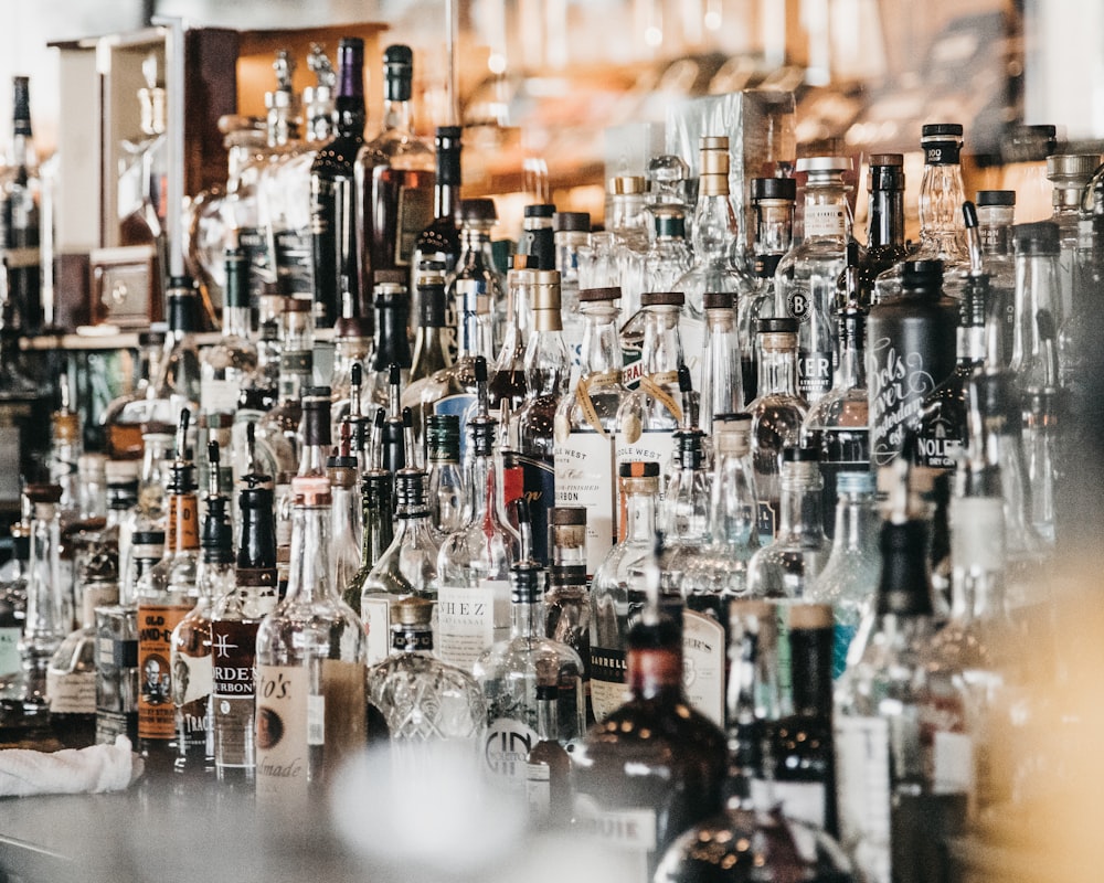 a large amount of liquor bottles on a bar
