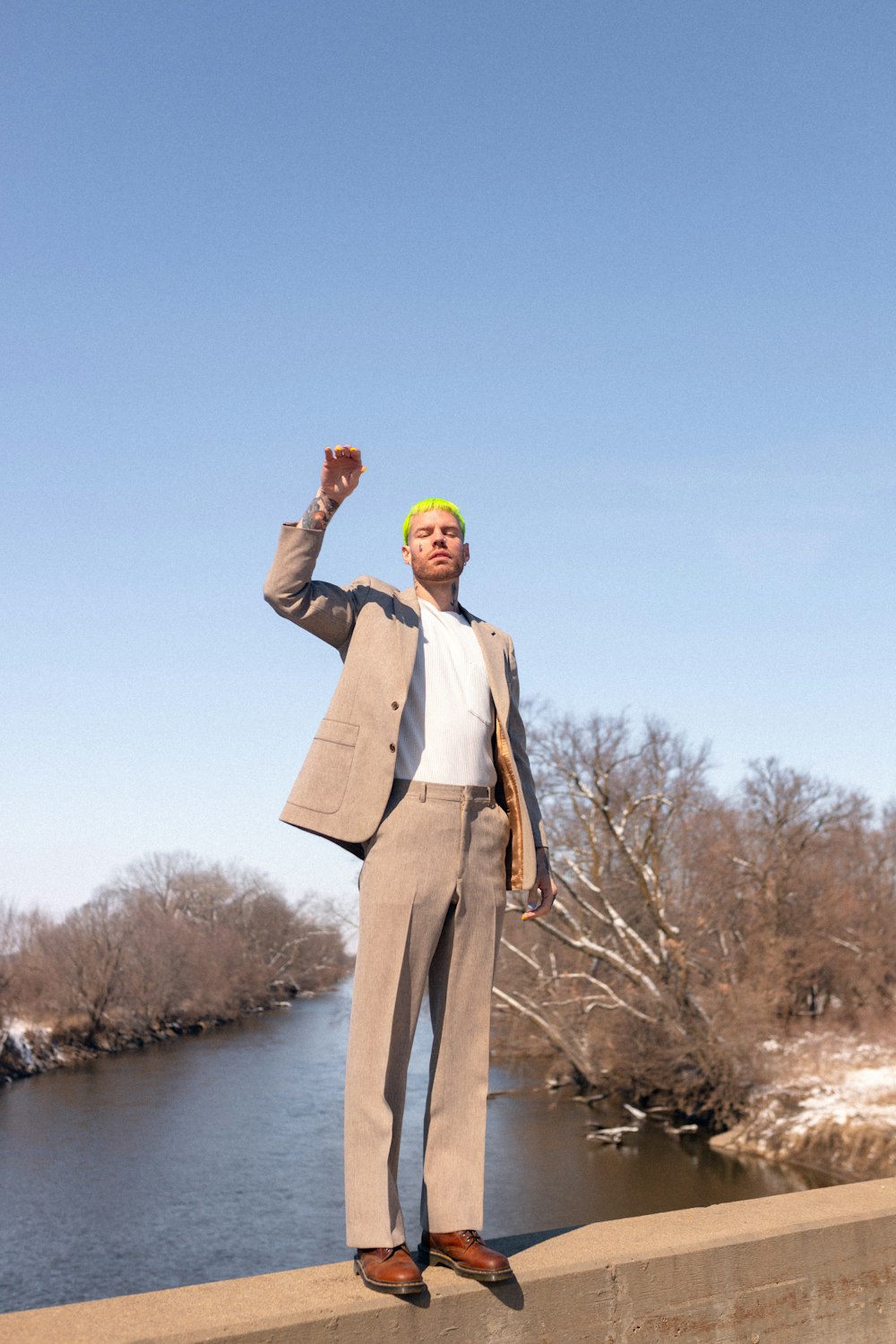 a man in a suit standing on a bridge