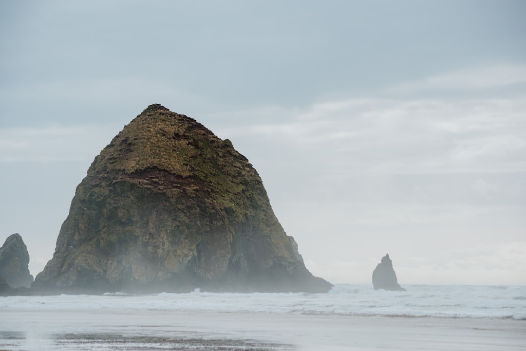 a large rock sticking out of the ocean,