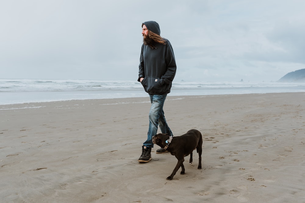 a man walking a dog on a beach