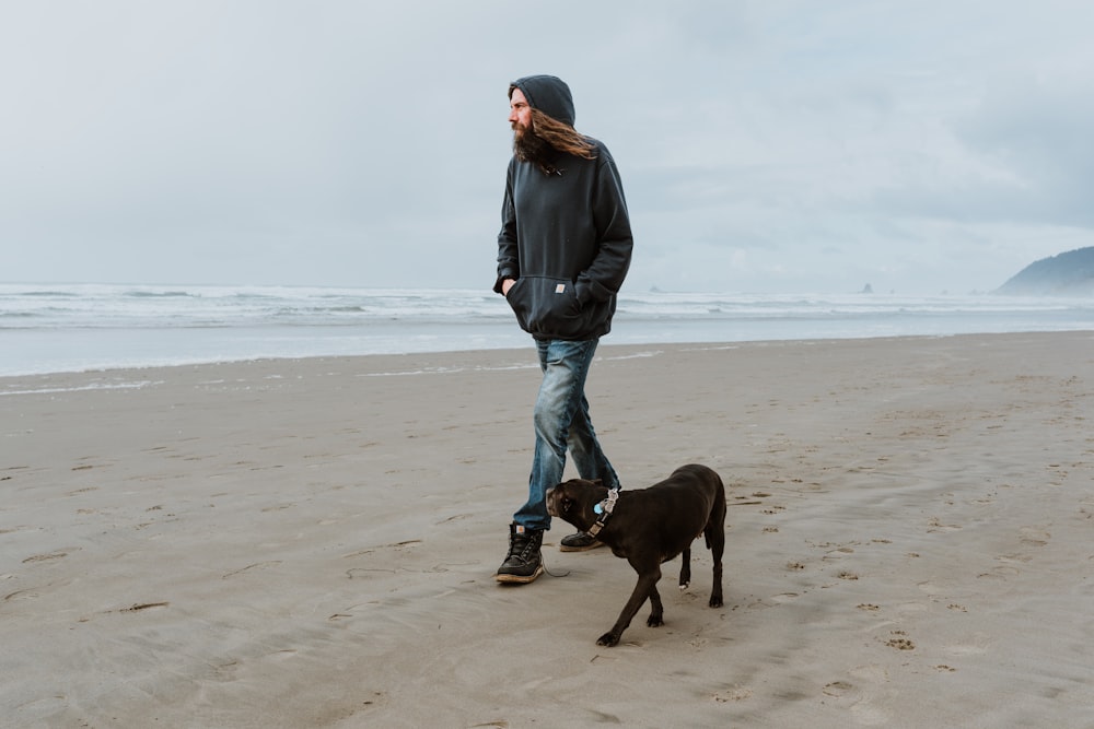 해변에서 개를 산책시키는 남자