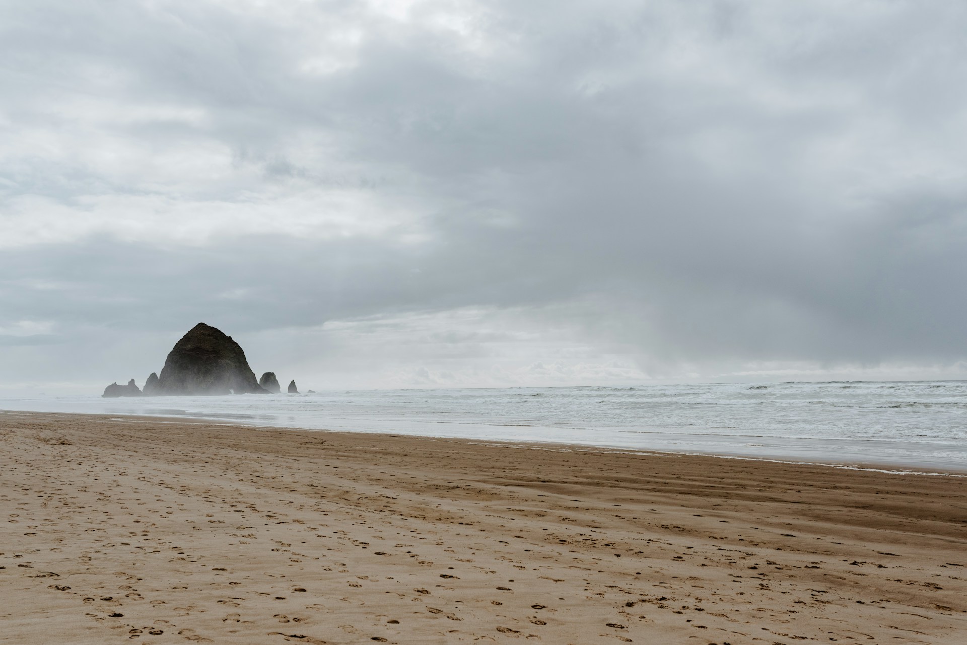 a sandy beach with footprints in the sand