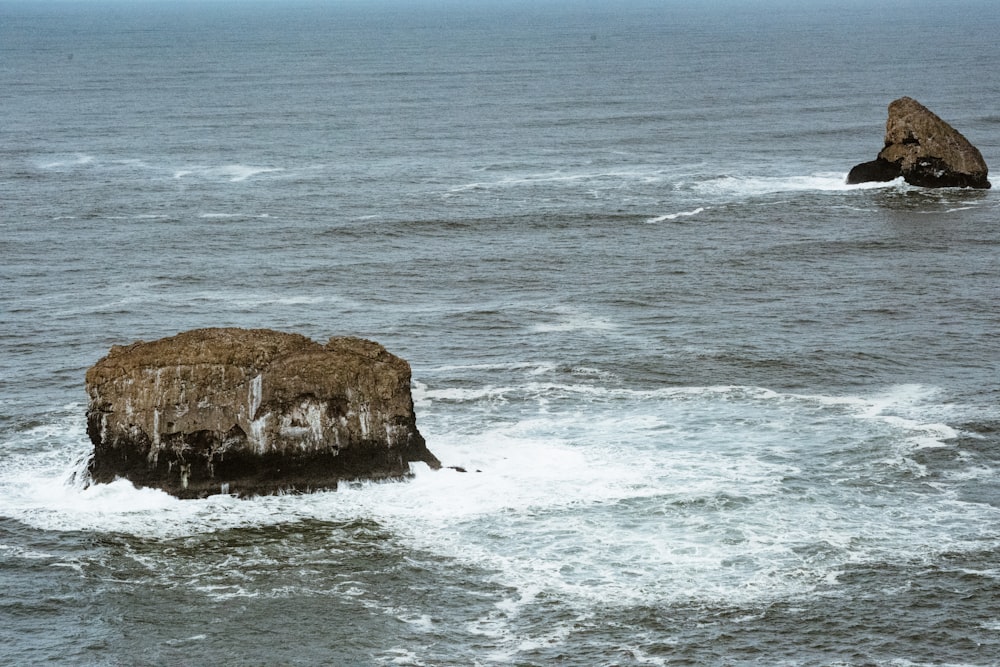 a large rock in the middle of the ocean