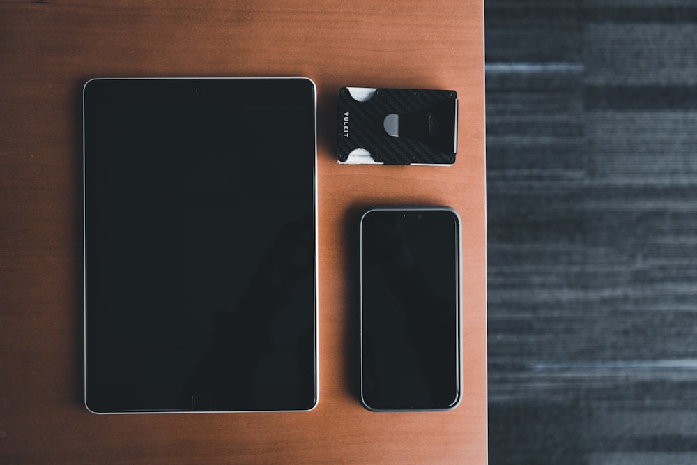 a cell phone, wallet, and charger sitting on a table