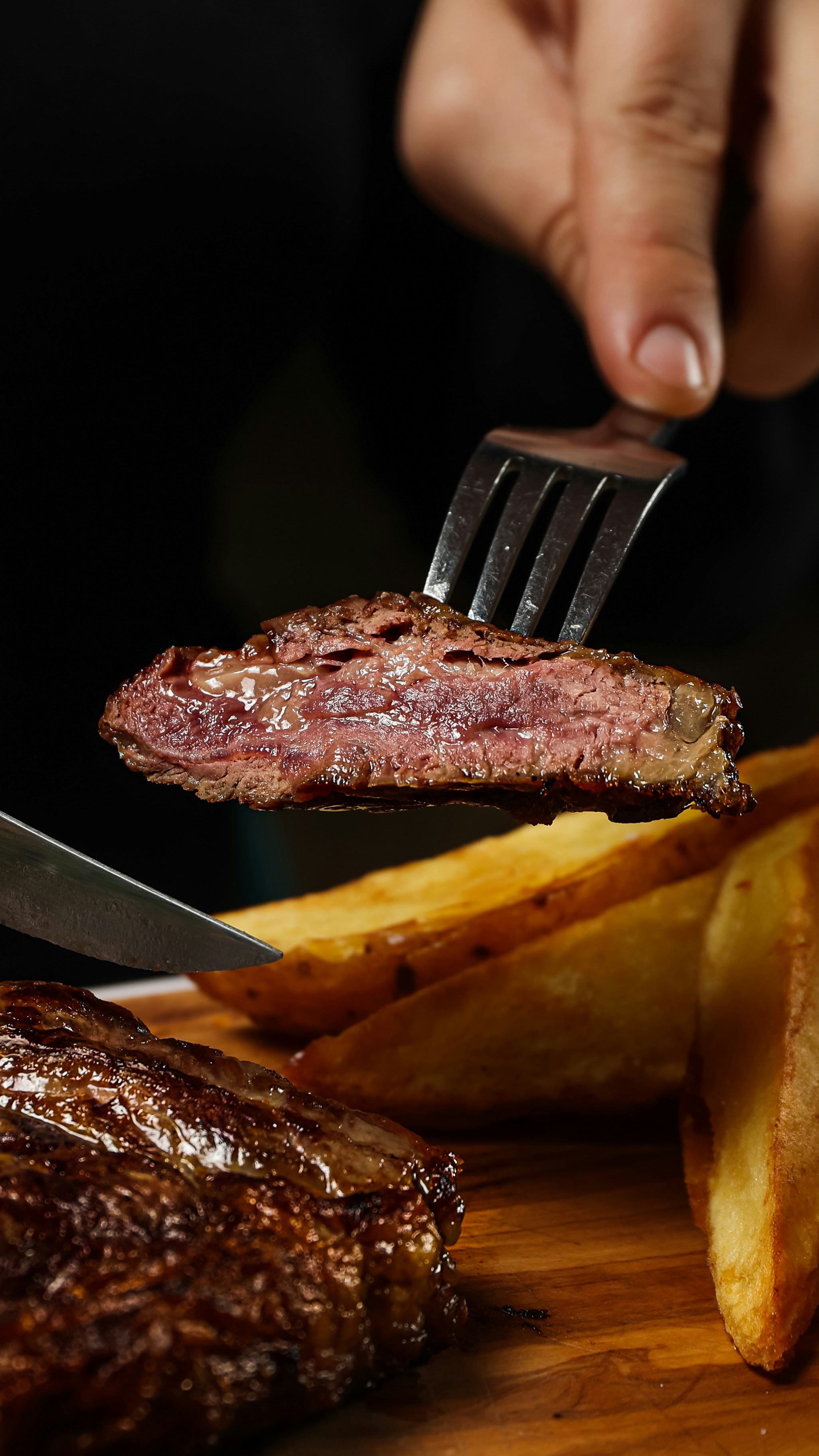 Thick rib eye steak perfectly seared with char marks, served with golden fries