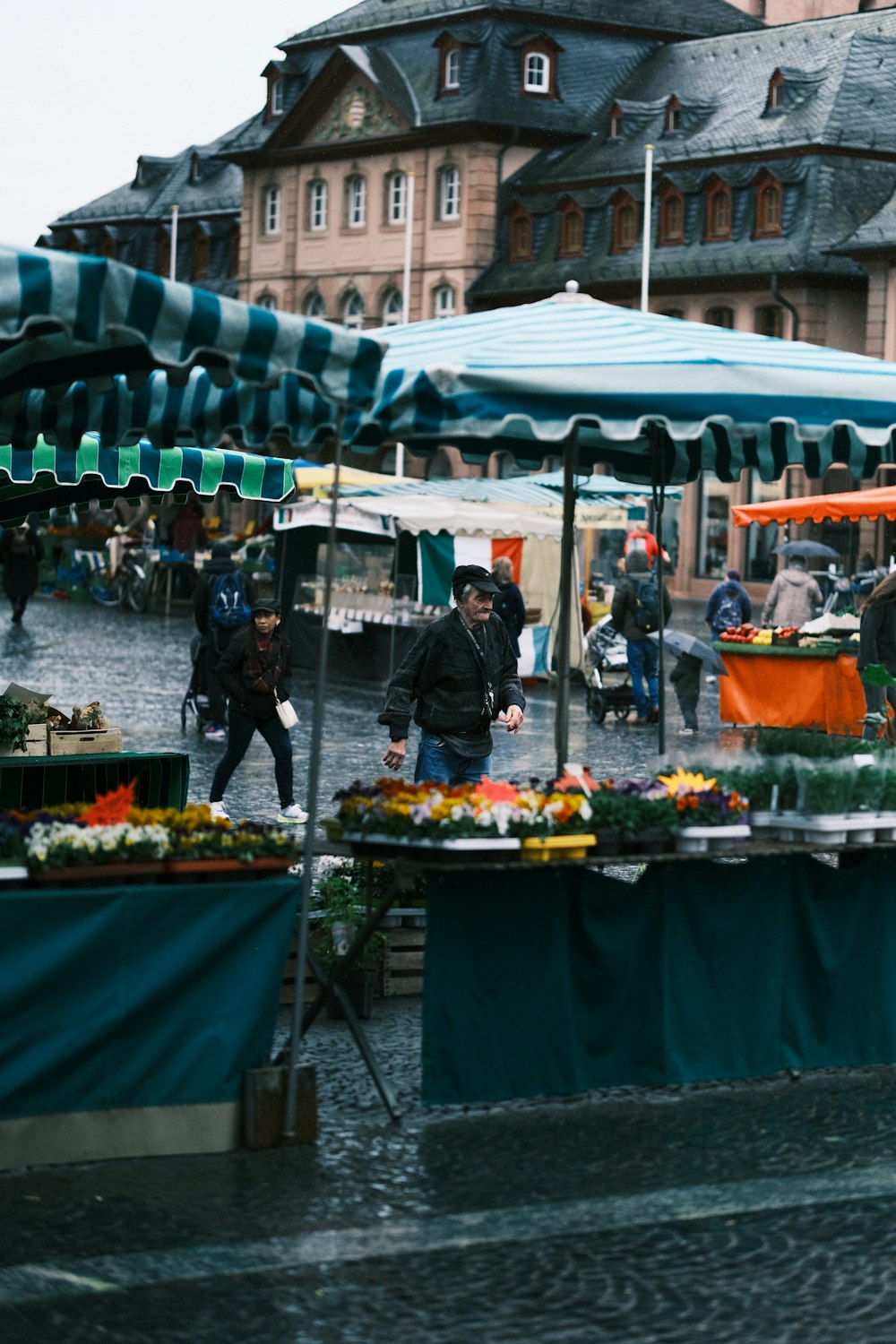 a group of people walking around a farmers market